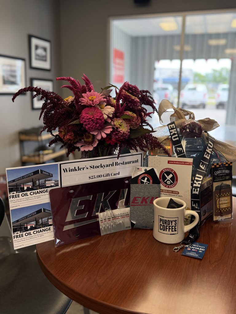 Grand Prize giveaway including local vendor gifts. A flower arrangement from Jo's Greenhouse; EKU license plate, EKU lanyard, and EKU koozie from Campus Wearhouse; Mug and gift card from Purdy's Coffee; Brady's Sushi and Hibachi gift card and menu, $25 gift card from Winkler's Stockyard Restaurant, Candleberry air freshener and tart warmer from Jillian's; car care package including four free detail gift cards and four oil changes gift certificate. 